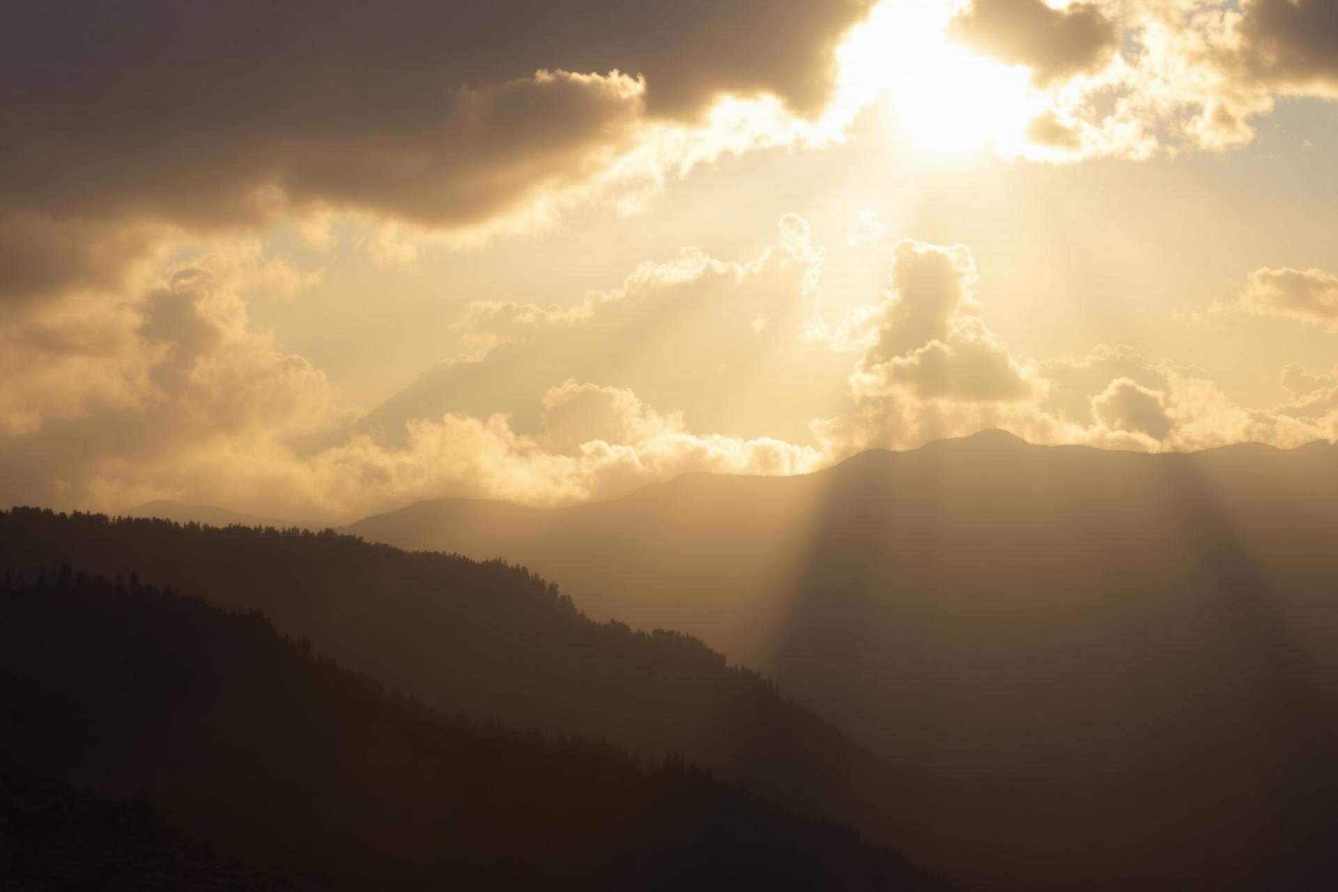 Light breaking through clouds over mountains